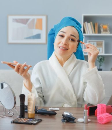 happy-young-asian-woman-with-towel-her-head-sitting-dressing-table-home-interior-applying-eyeshadows-doing-morning-makeup-routine_141793-130893